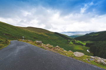 Wicklow Military Road in Ireland. Irish landscape. Empty road in the mountains. 
The Wicklow Mountains view in Ireland. Irish landscape. Green dark view.