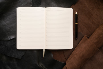 Flat lay - Notepad and pen on a leather background. workplace concept. copy space