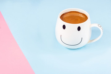 Black coffee in a white mug on a pink and blue background