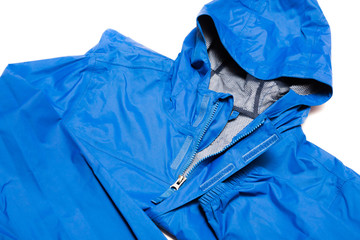 Folded blue zipper windbreaker jacket, rain proof and waterproof hiking Gore-Tex jacket hoodie. Track jacket sport nylon full zip isolated on white. Folded clothes. Outer layer garment for travel.