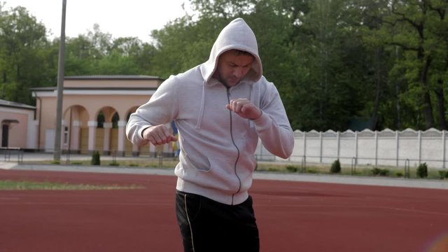 young man warms up before jogging in park
