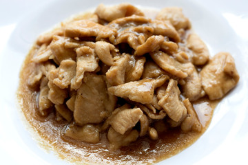 Pork stir fry with garlic, pepper, on a white plate.
