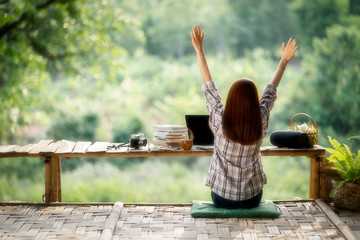 The young woman raised her hand with joy, the attractive girl enjoying her time on the wooden terrace. Quiet, beautiful,