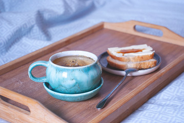 Breakfast in the bed. Big cup of tea on a tray. Comfort of home atmosphere.