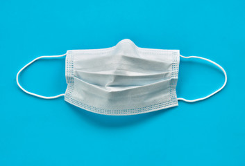 Surgical mask isolated on a light blue background