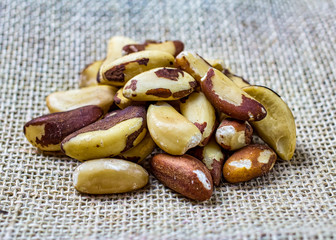 Brazil nuts Bertholletia excelsa, aka Castanha-do-Brazil or Castanha-do-Para, in detail. Handful or portion of Brazil nut on jute fabric