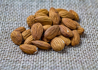 Almonds in detail. Handful or portion of almonds on jute fabric