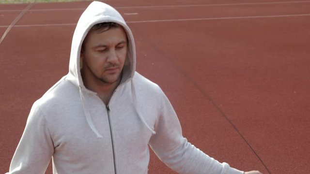 portrait of a runner in a white shirt jumping with a skipping rope