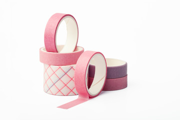 Pink and purple rolls of washi tape on a white background