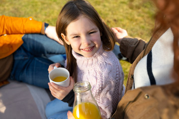 Adorable little girl holding cup of orange juice