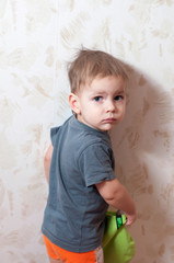 a boy standing against the wall