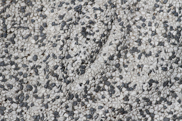 Concrete, plaster, wall covering, flooring made of small pebbles. Concrete made by mixing tiny black pebbles. Stone floor wall background brick pattern gray backdrop.