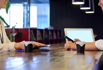 オフィスでのノートパソコンとスマートフォンを使ってミーティングをしている男性と女性