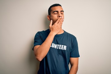 Young handsome african american man volunteering wearing t-shirt with volunteer message bored yawning tired covering mouth with hand. Restless and sleepiness.