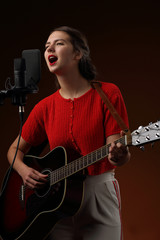 A girl singing a song to the accompaniment of a guitar