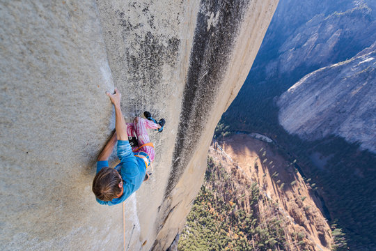 Climbing holding on sideway in crazy position to free climb the Nose