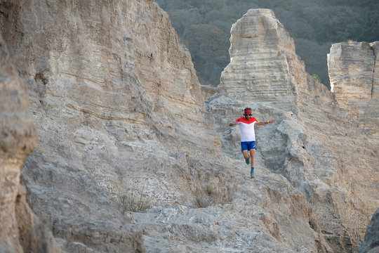 One man trail running on a sandy terrain made of old mining waste