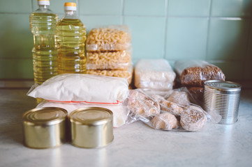Volunteer donation various product set for poor or elderly people. Pandemic coronavirus food shortages. Food donations or delivery concept on kitchen background. 