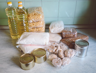 Volunteer donation various product set for poor or elderly people. Pandemic coronavirus food shortages. Food donations or delivery concept on kitchen background. 