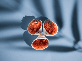 Orange bath salt with shells on a blue background with a shadow from a tropical plant. Copyspace,...