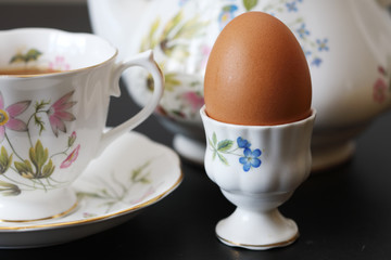 Continental breakfast with a teapot on a black table
