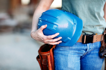 Close up of a female construction worker holding a hard hat