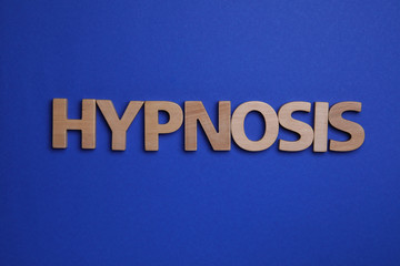 Word HYPNOSIS made with wooden letters on blue background, flat lay