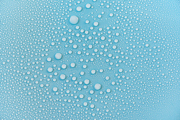 Close-up drops of water on blue surface, raindrops, background or texture 