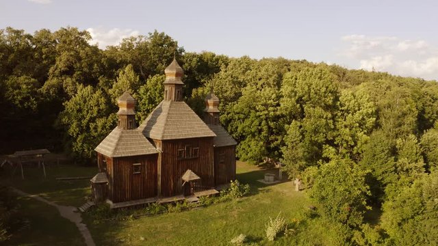 Traditional wooden church in a forest. Aerial dron view. Medieval church in outdoor historical museum.