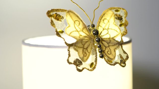 Decorative golden butterfly on a lamp in an apartment - closeup