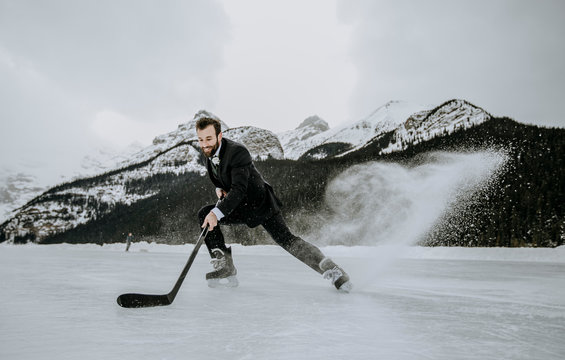 Hockey Player In Suit Stops Fast Kicking Up Frozen Spray On Lake