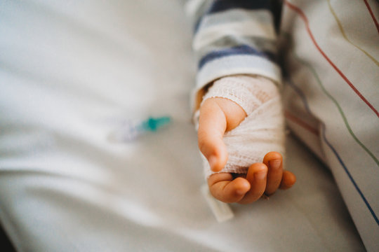 Baby child hand with IV sick at the hospital with a virus coronavirus