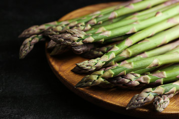 Fresh raw asparagus on black table, closeup
