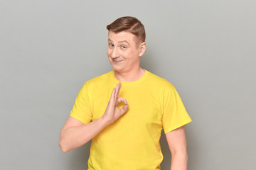 Portrait of happy cheerful mature man showing okay gesture and smiling