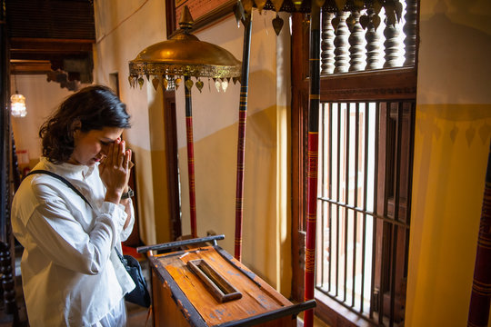 buddhist worshiper donating at the temple of the holy tooth relic