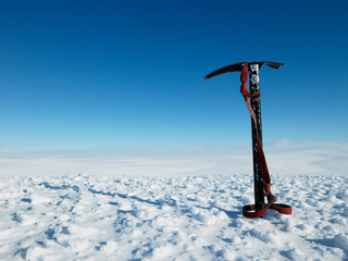 Ice pick stuck in snow on top of a mountain