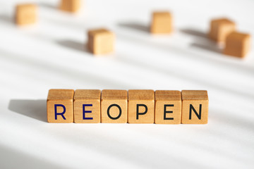Reopen concept after the coronavirus pandemic. Wooden blocks with text isolated on white background