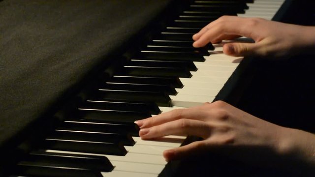 Close up of young pianist hands playing music
