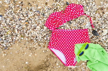 Swimwear on sandy beach, top view