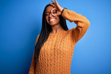 Young african american woman wearing casual yellow sweater standing over blue isolated background...