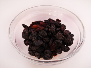 Appetizing raisins lies in a transparent plate