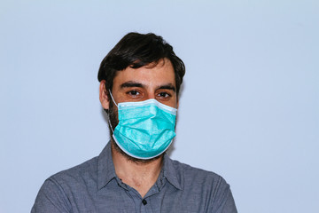 portrait of man with beard and casual clothes and surgical mask on white background. social distancing