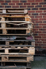 Shabby wooden pallets near brick wall