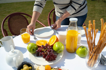 Woman setting beautiful table for outside dinner