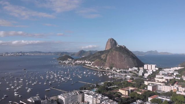 Sugarloaf mountain and Urca neighbourhood on Guanabara bay port with pleasure boats in the foreground against a blue sky