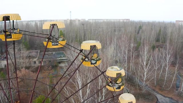 Ferris wheel in Pripyat, Chernobyl. With abandoned buildings in the exclusion zone. Aerial video with drone