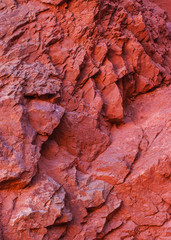The fractured surface of a red rocky slope.