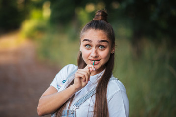Fototapeta premium Girl with a candy on a stick on the nature