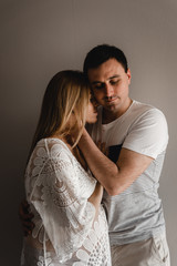 husband gently hugs his pregnant wife,happy couple will soon become parents,belly of a pregnant girl,last days of pregnancy