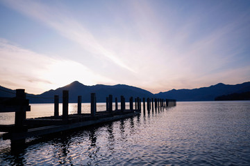 Beautiful sunset over the lake with pier. Romantic landscape with lake